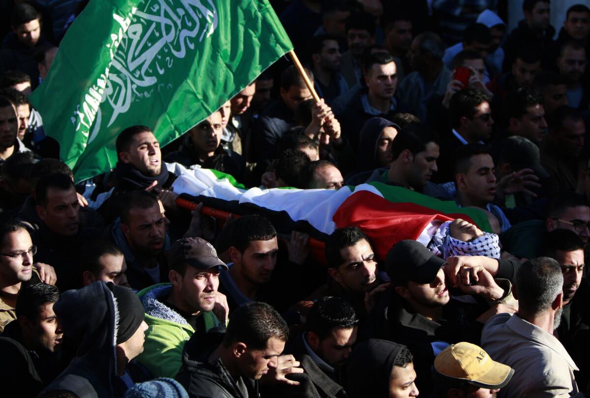 Palestinians carry the body of Muhammad Mubarak during his funeral in the Jalazoun refugee camp near the West Bank city of Ramallah.