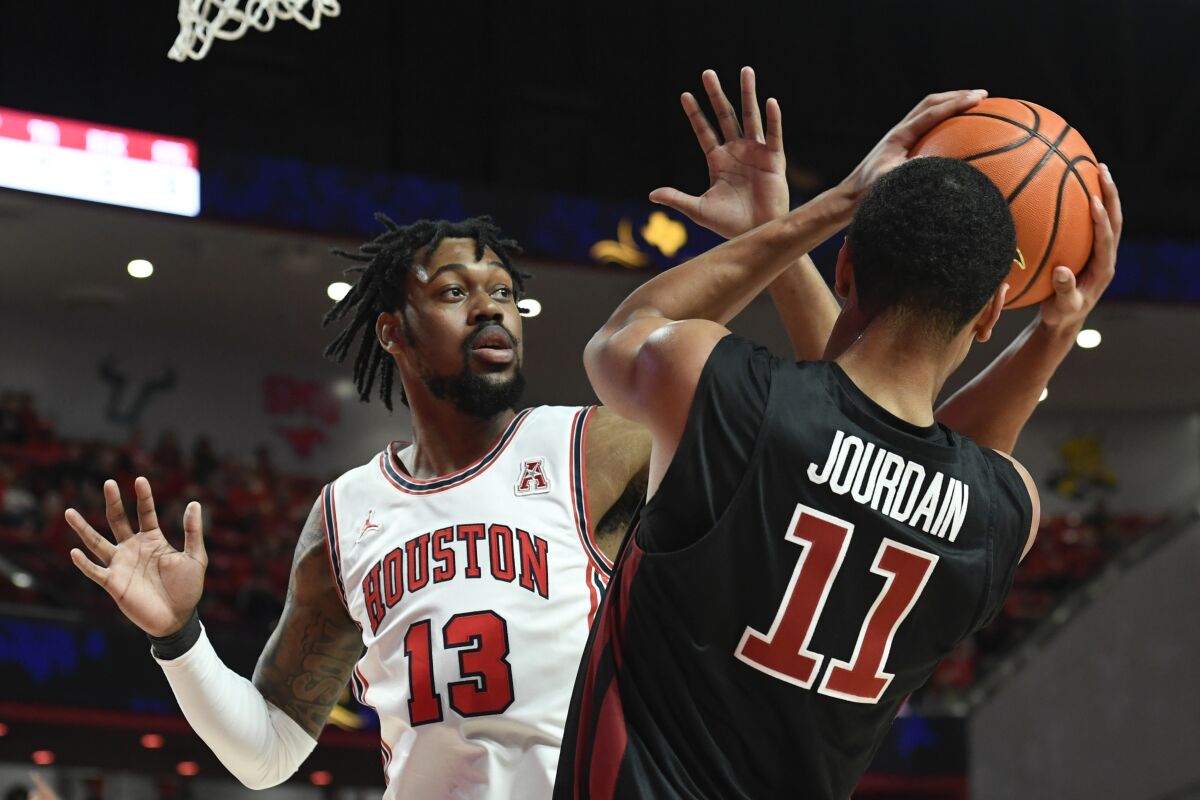 Houston forward J'Wan Roberts (13) attempts to block a pass by Temple forward Nick Jourdain (11) during the first half of an NCAA college basketball game Thursday, March 3, 2022, in Houston. (AP Photo/Justin Rex)