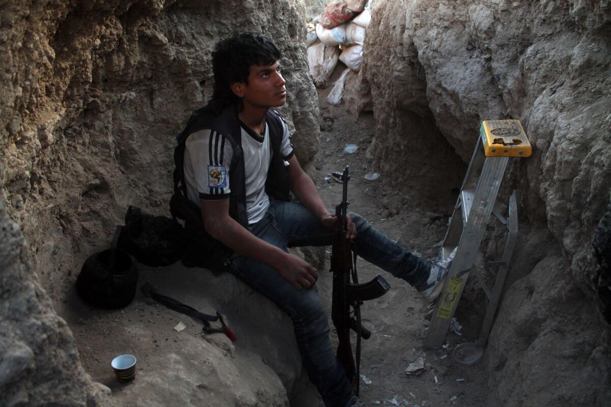 A Syrian opposition fighter is seen in a trench in the northeastern city of Dair Alzour during clashes with pro-government fighters, on March 21, 2014.