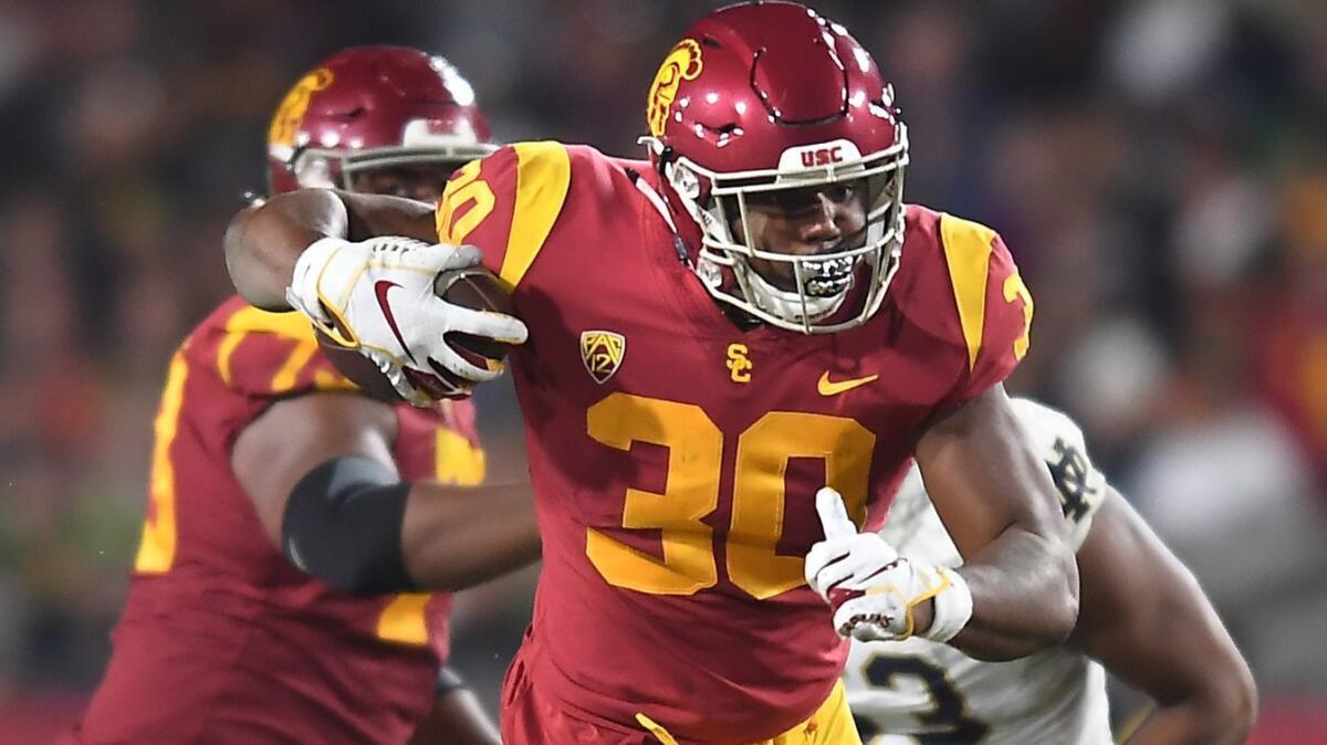 USC running back Markese Stepp tries to break a tackle by a Notre Dame' defender at the Coliseum on Nov. 24, 2018.