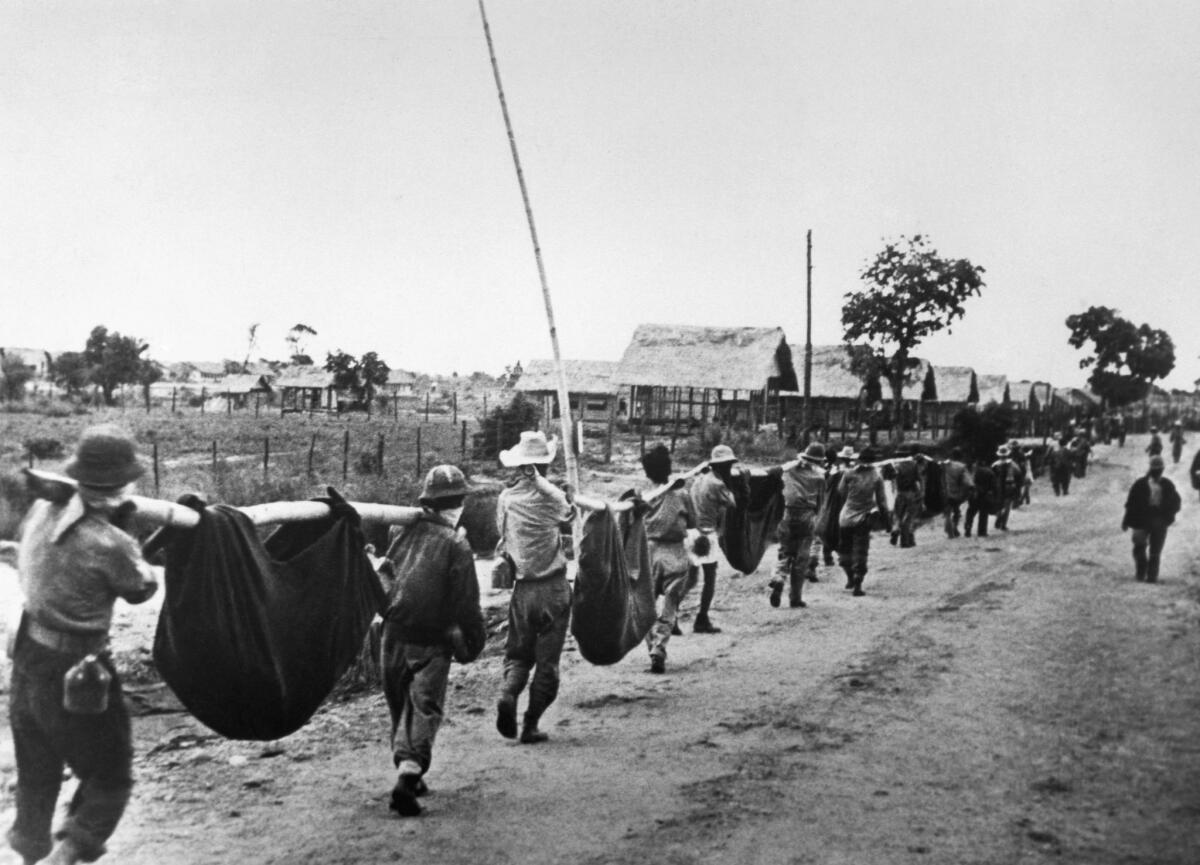 American prisoners of war use improvised litters to carry casualties in April 1942 as they near a Japanese POW camp about 65 miles inland from the Bataan Peninsula. (Corbis via Getty Images)