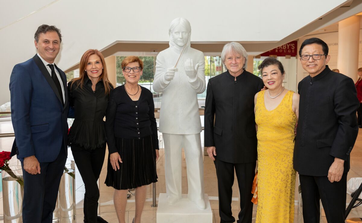 From left to right, John Forsyte, president of the Pacific Symphony; event chairwoman Diana Martin; Joann Leatherby, board chair of the Pacific Symphony; Music Director Carl St.Clair; and Ling Zhang and Charlie Zhang. The group is posing with a recently unveiled statue of St.Clair, who just marked 30 years as the Pacific Symphony's maestro.