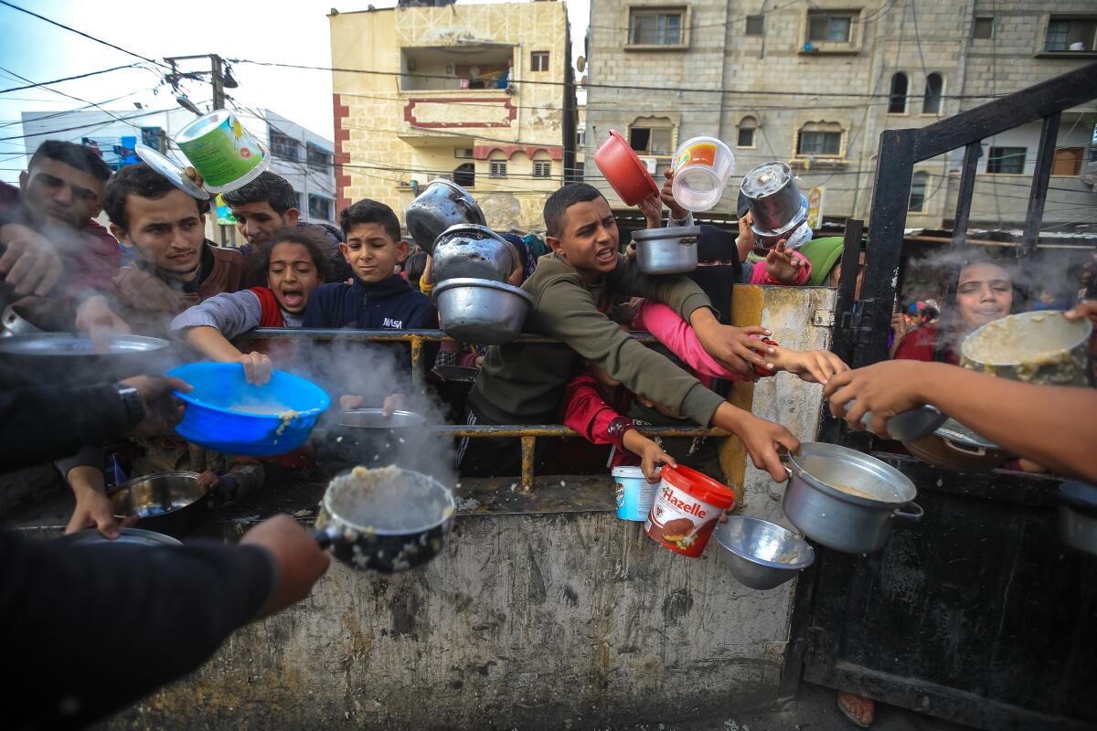 Palestinians wait to collect food at a donation point 