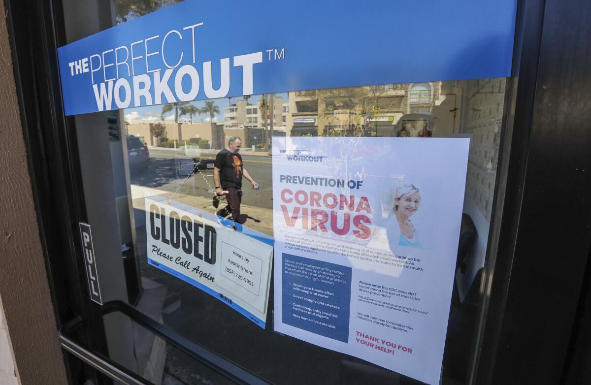 The Perfect Workout in La Jolla with closed and coronavirus-related signs on its door.