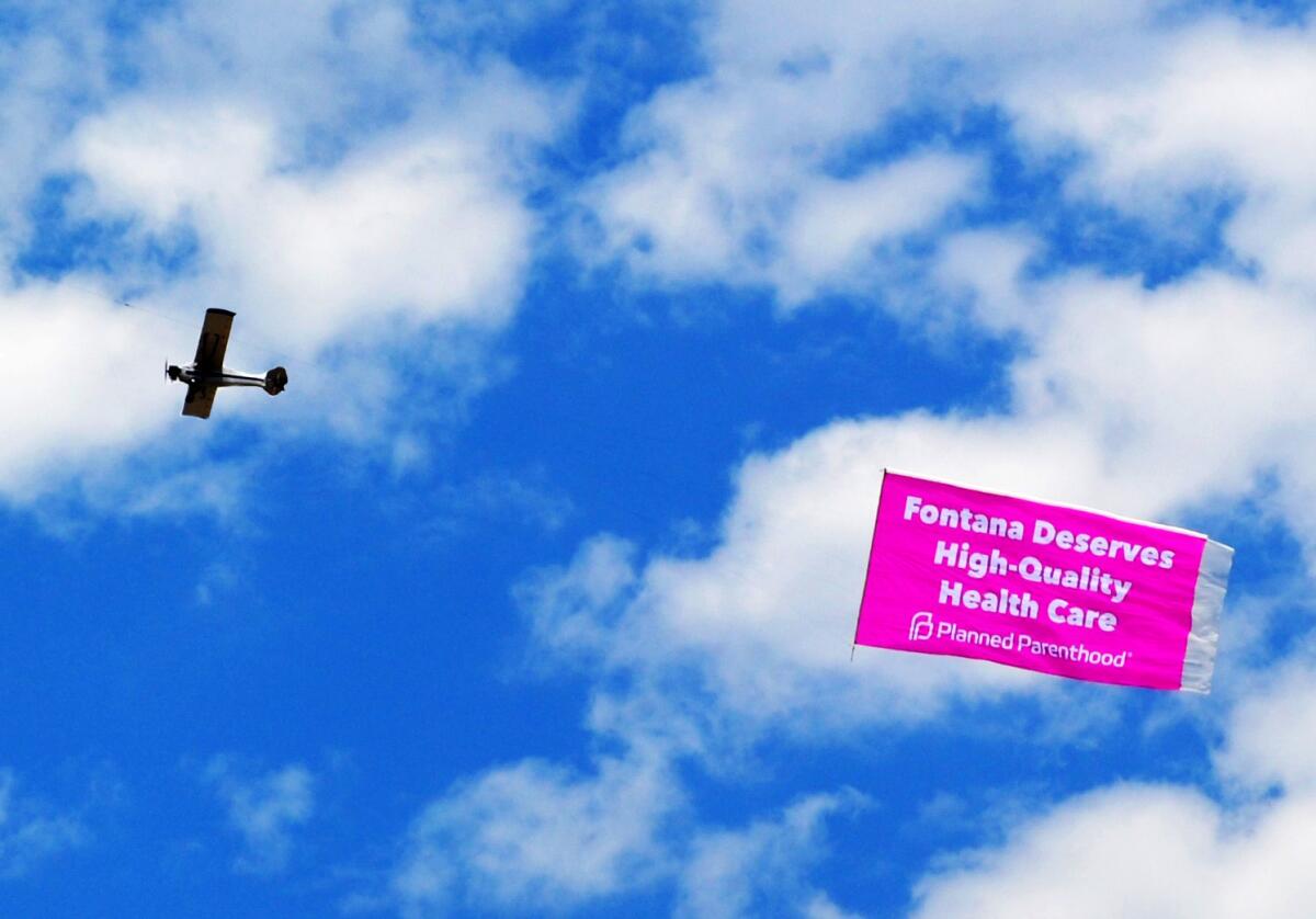 A plane flies with a banner that says, "Fontana Deserves High Quality Health Care."