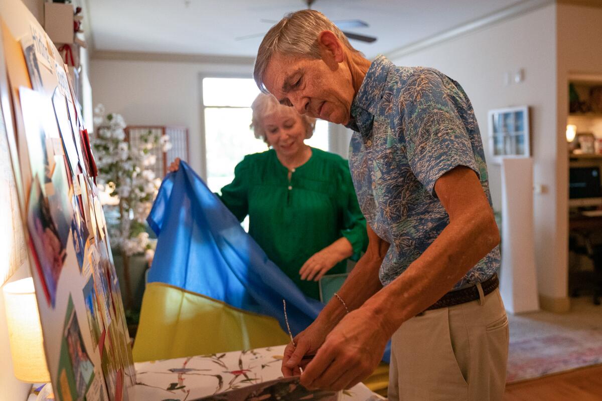 Greg Dawson looks at old family photos with his wife, Candy, at their home in Florida.