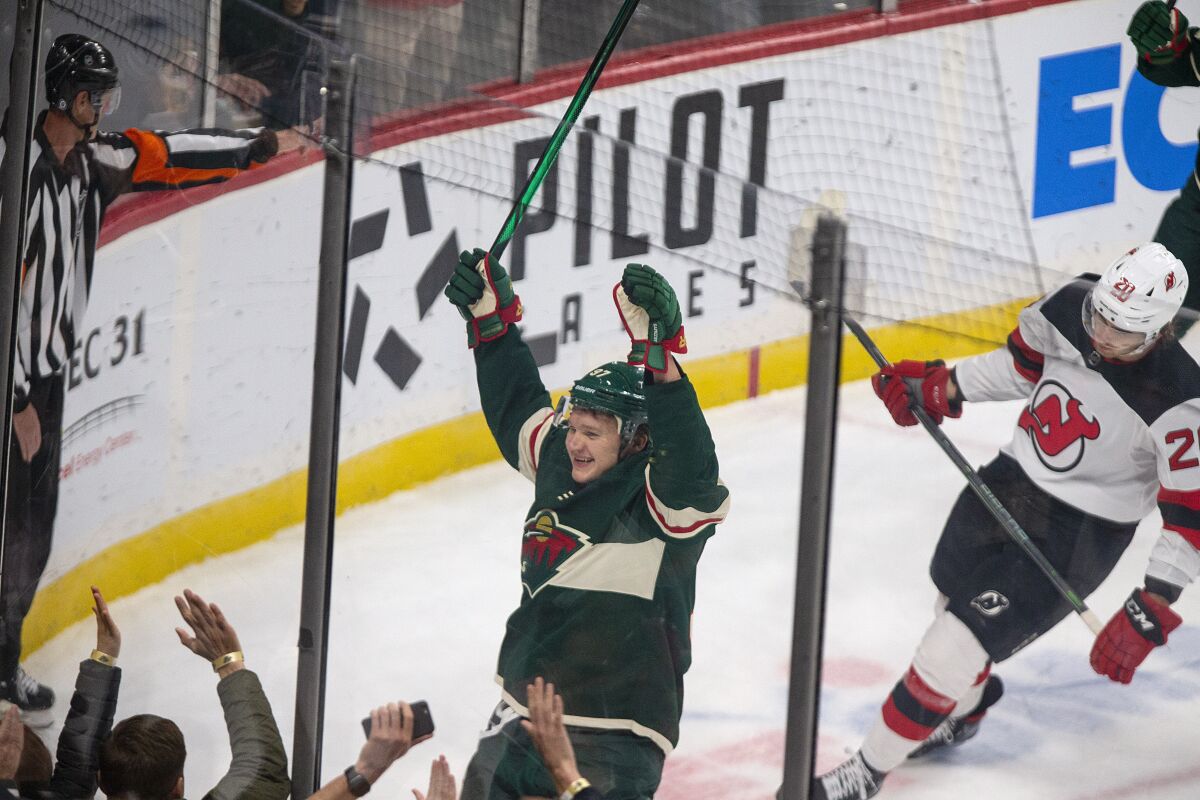 Minnesota Wild left wing Kirill Kaprizov (97) celebrates a goal as New Jersey Devils center Michael McLeod (20) skates away during the first period of an NHL hockey game, Thursday, Dec. 2, 2021, in St. Paul, Minn. (AP Photo/Andy Clayton-King)