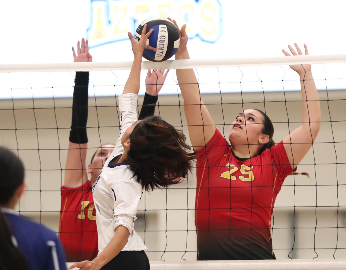 Estancia's Emily Loza (25) jousts at the net with La Quinta's Helene Trantien in a Coast League match on Tuesday.