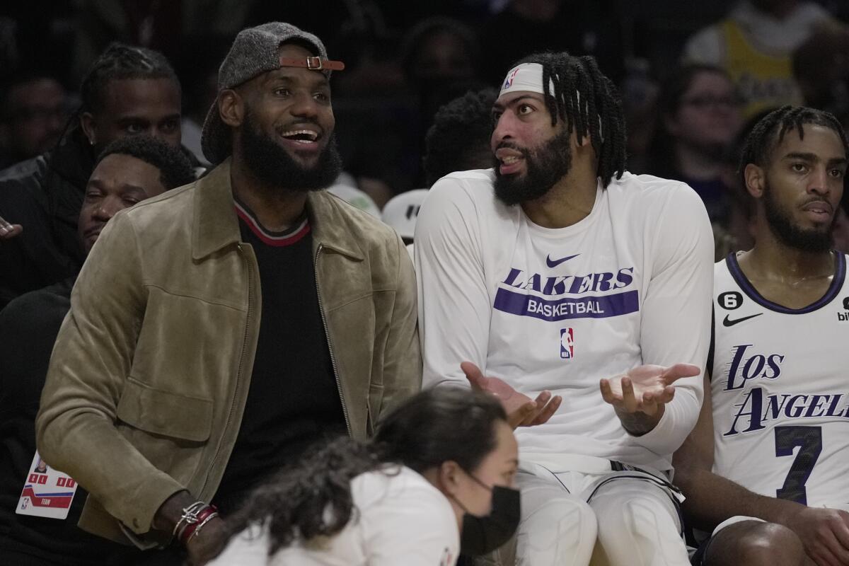 Lakers forward LeBron James and forward Anthony Davis sit on the bench.