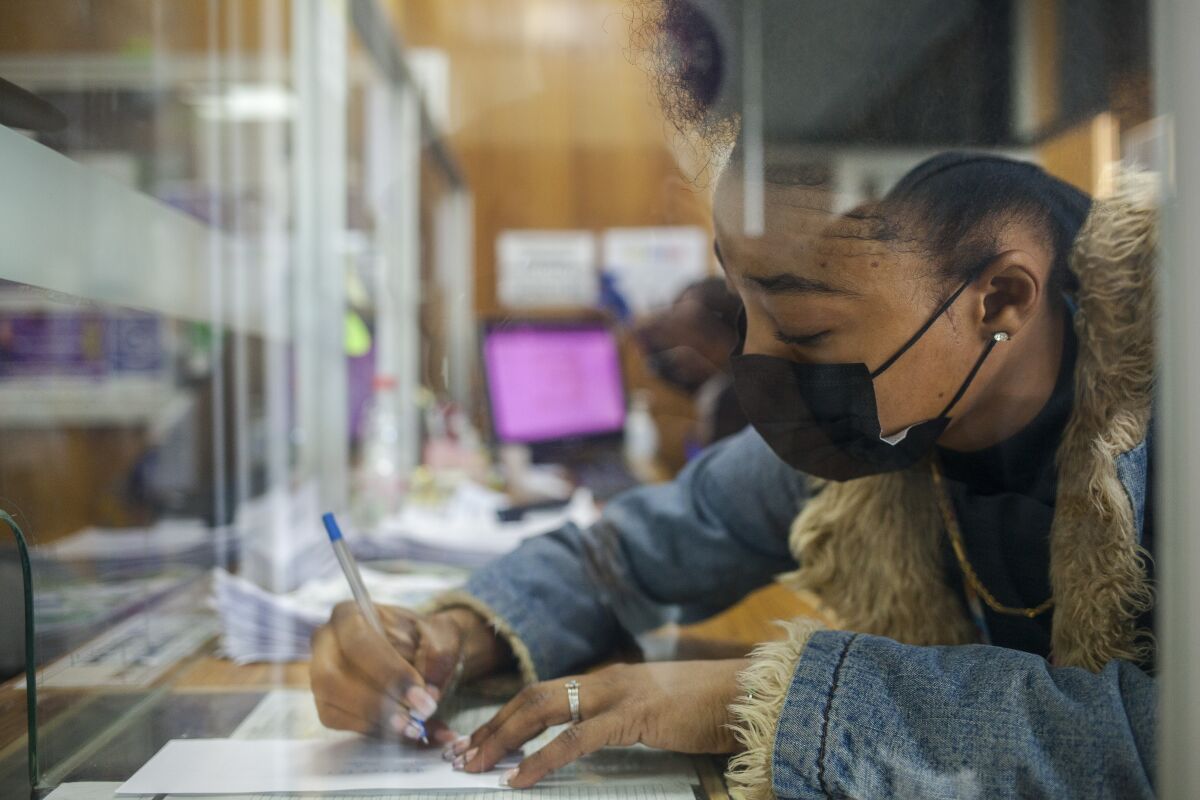 Widenska Andre, 21, answers questions at the desk of a migrant aid agency