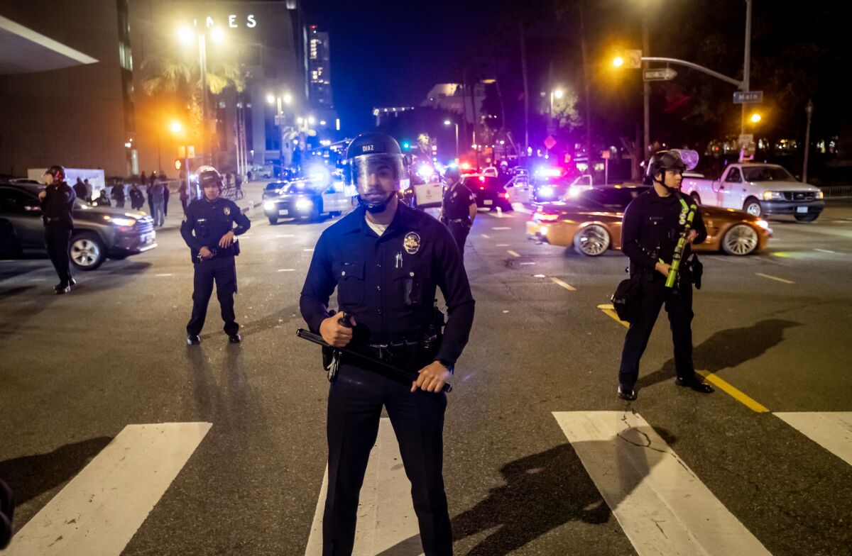 Police keep protesters from advancing into an intersection in downtown Los Angeles.