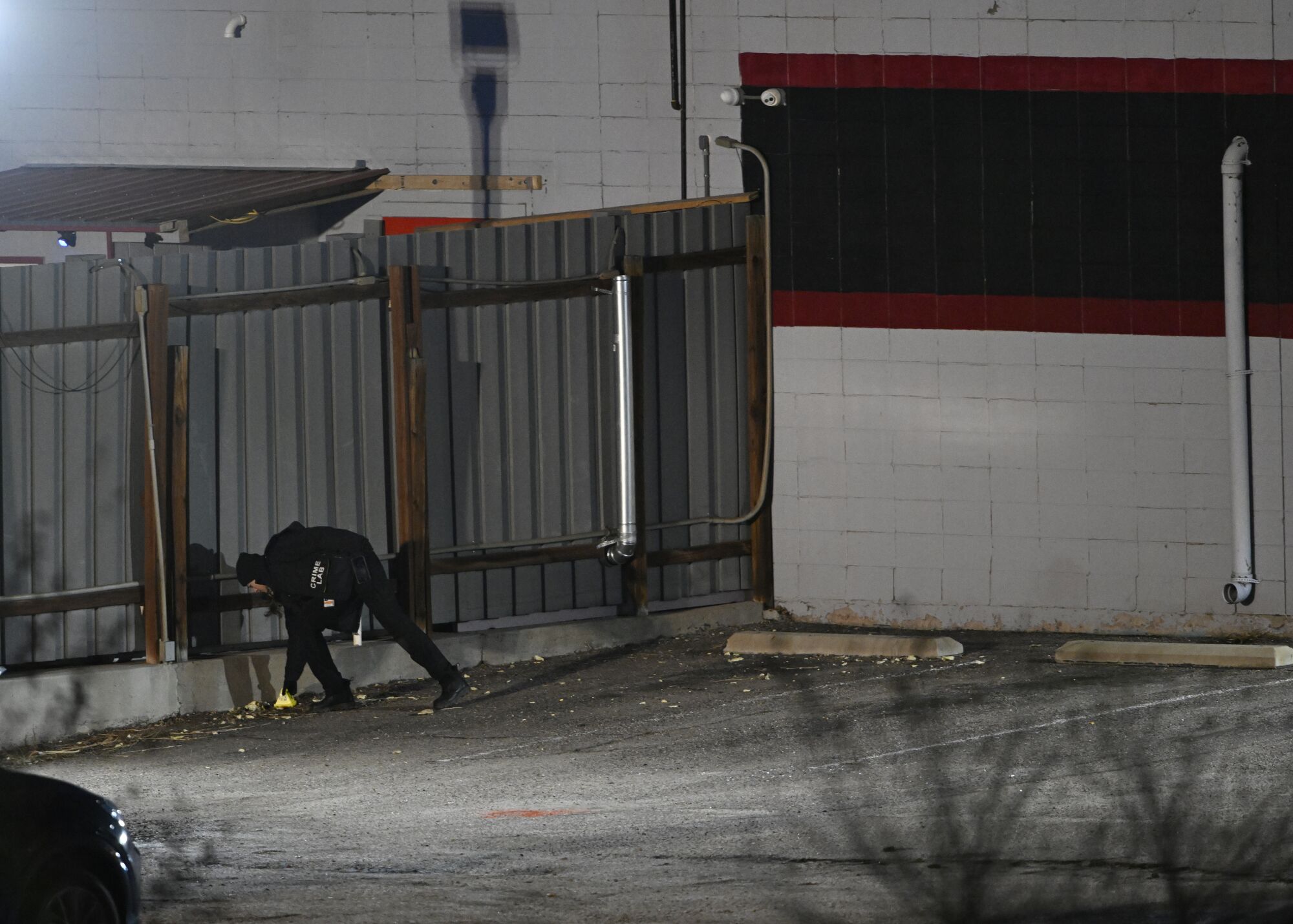 A member of the FBI works on the investigation in the parking lot of Club Q.