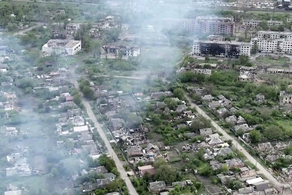 An aerial image shows destroyed homes and blackened apartment buildings. 