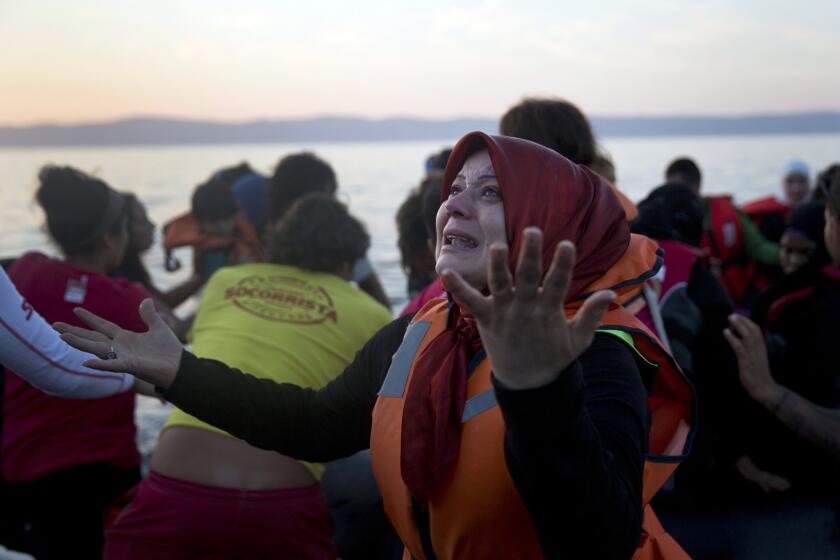A Syrian woman reacts as she arrives at the island of Lesbos, Greece, after crossing from Turkey aboard a dinghy.