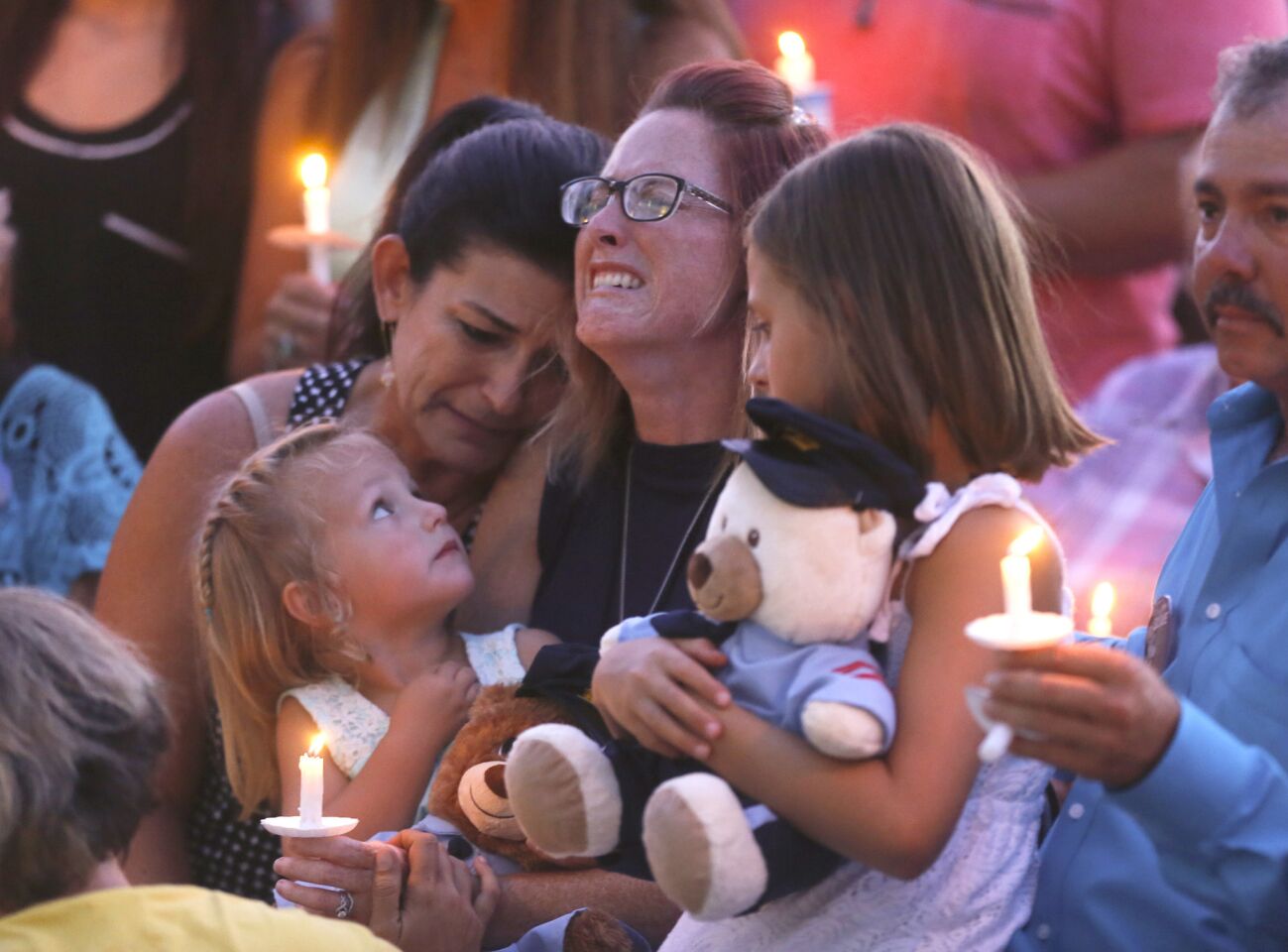 Dechia Gerald, widow of slain Baton Rouge Police Officer Matthew Gerald, weeps while she cradles her two daughters on her lap during a candlelight vigil at the Healing Place Church.