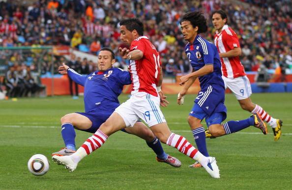 Marcus Tulio Tanaka of Japan tackles Lucas Barrios of Paraguay during the 2010 FIFA World Cup South Africa Round of Sixteen match between Paraguay and Japan at Loftus Versfeld Stadium on June 29, 2010 in Pretoria, South Africa.
