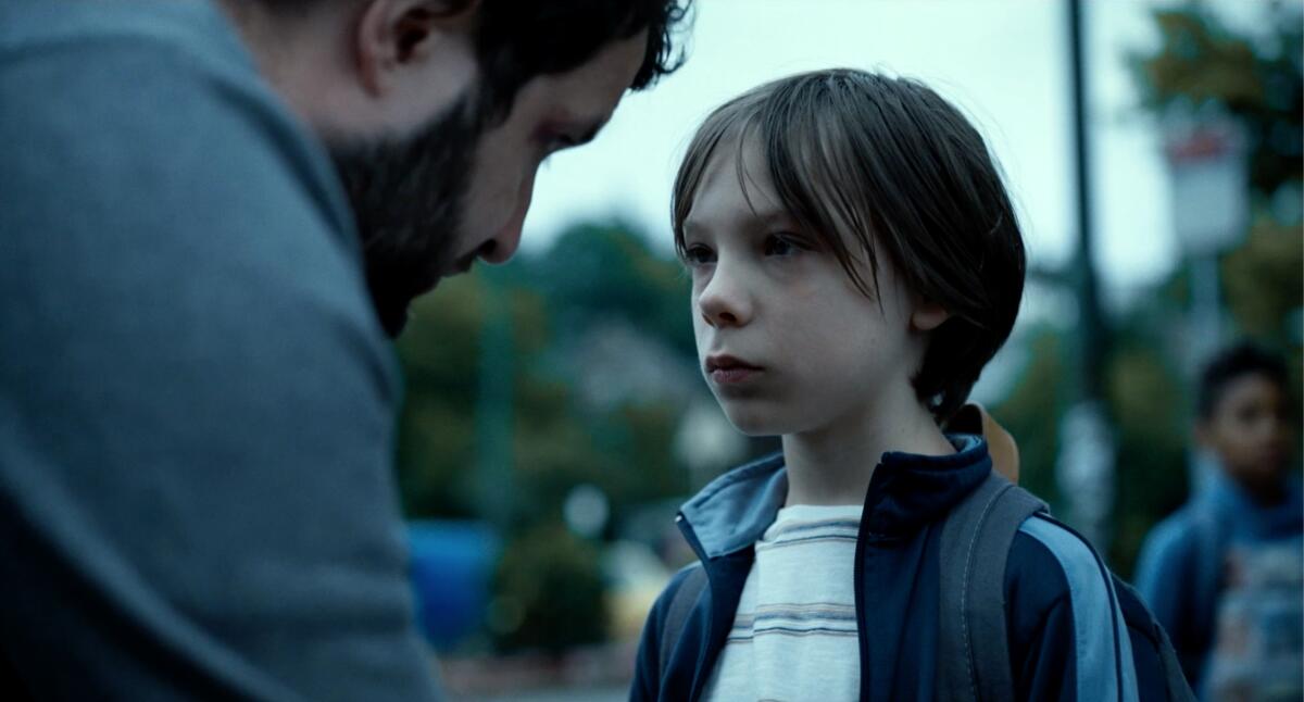 A man leans down to talk to his son.