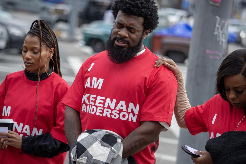 SANTA MONICA, CA - FEBRUARY 18: JaQuel Knight, center, leads a prayer before protesters march to a protest/disruption at Frieze Los Angeles on Saturday, Feb. 18, 2023 in Santa Monica, CA. (Brian van der Brug / Los Angeles Times)