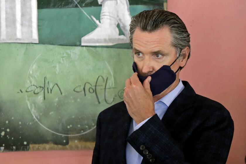FILE - In this June 9, 2020 file photo Gov. Gavin Newsom wears a protective mask on his face while speaking to reporters at Miss Ollie's restaurant during the coronavirus outbreak in Oakland, Calif. Newsom said Wednesday, June 23, 2020, that he will leverage $2.5 billion in the upcoming state budget to penalize counties that fail to comply with the state's mandates on wearing masks, testing and other measures meant to slow the spread of the coronavirus. (AP Photo/Jeff Chiu, Pool, File)