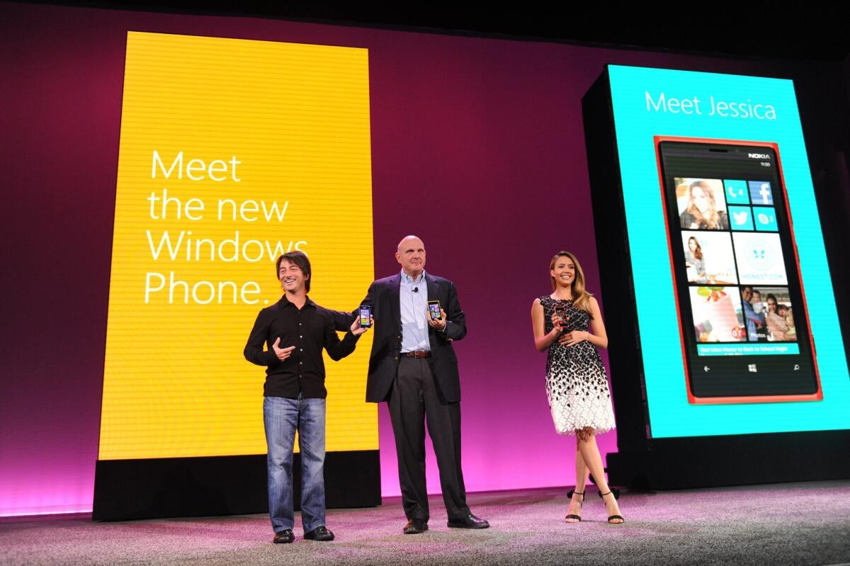 At an event in San Francisco in October, Microsoft's Joe Belfiore, left, CEO Steve Ballmer and actress Jessica Alba unveiled the Windows 8 phone. Now some numbers are in on the company's financial performance for the quarter.