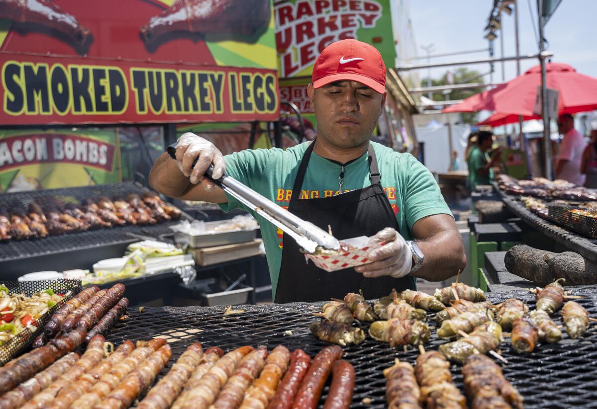 Antonio Sotomayor prepares a bacon-wrapped jalapeno on Thursday at the Orange County Fair.