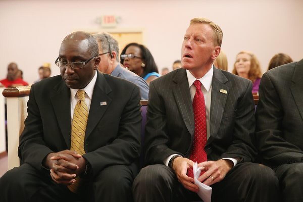 Sanford, Fla., Police Chief Cecil Smith, left, and Mayor Jeff Triplett attend a prayer vigil organized to promote peace and unity in the community in the wake of the George Zimmerman trial at the New Life World Center church on Monday.