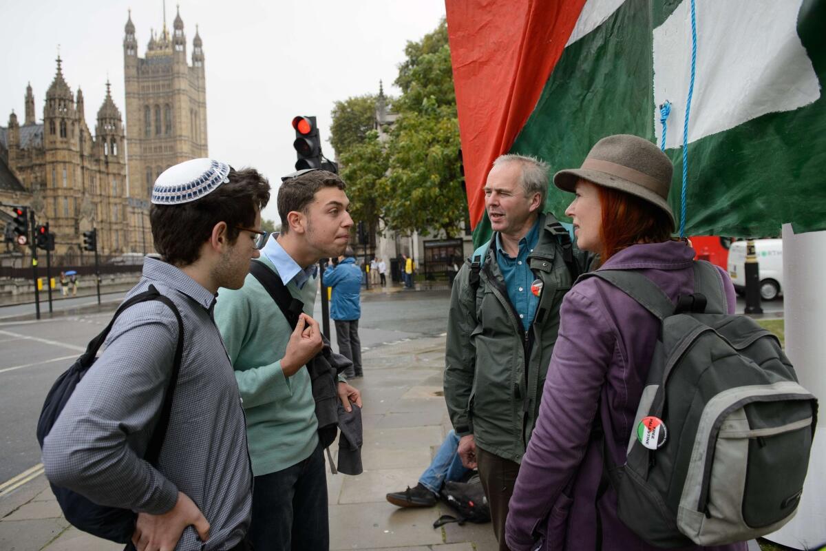 Young Jewish men argue with Pro-Palestinian supporters beside a giant banner calling for a recognized Palestinian State, in Parliament Square, central London on Oct. 13, 2014.