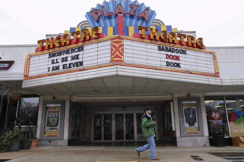 A man walks past the Plaza Theatre in Atlanta after the cinema announced via its Twitter account Tuesday that it would start showing the movie "The Interview" on Christmas Day.