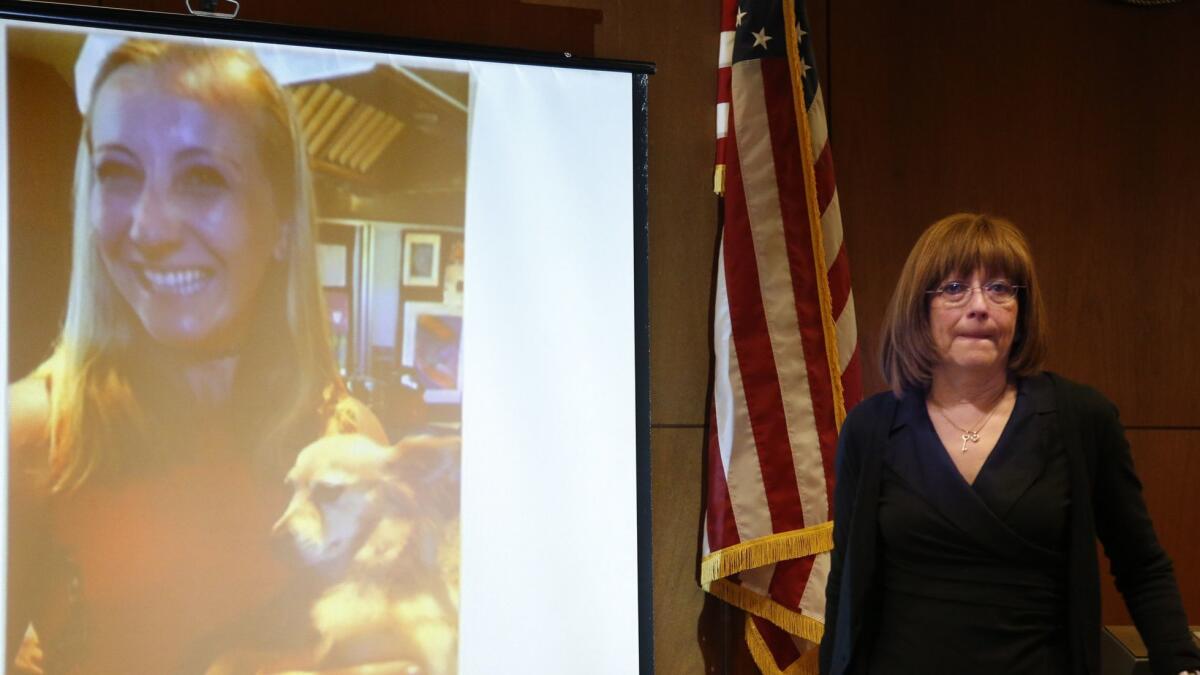 Andrea DelVesco's mother, Leslie, walks past a projected photo of her daughter during the preliminary hearing in the 2015 slaying.