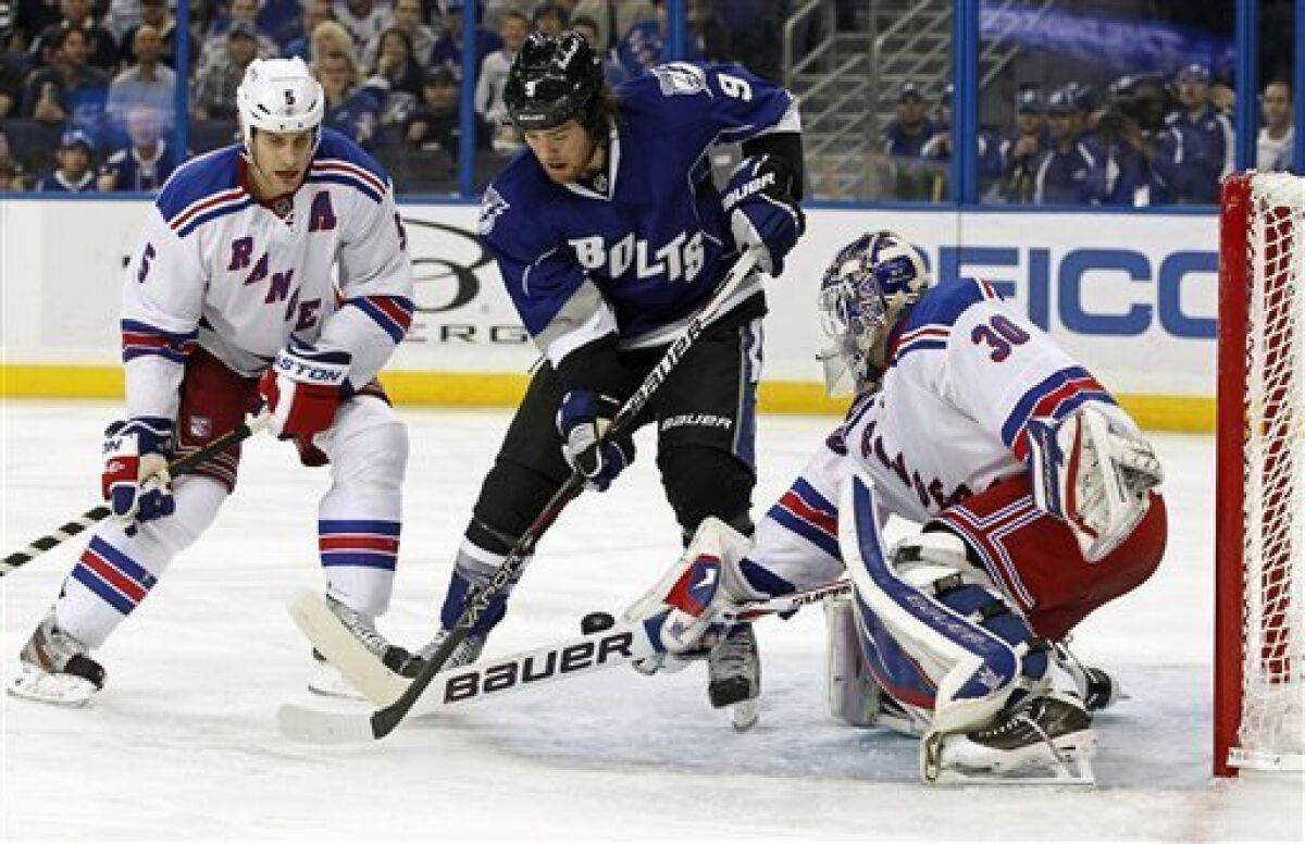 New York Rangers goalie Henrik Lundqvist, right, of Sweden, make a save on Tampa Bay Lightning's Steve Downie (9) as defenseman Dan Girardi looks on during the second period of an NHL hockey game, Saturday, Dec. 3, 2011, in Tampa, Fla. (AP Photo/Mike Carlson)