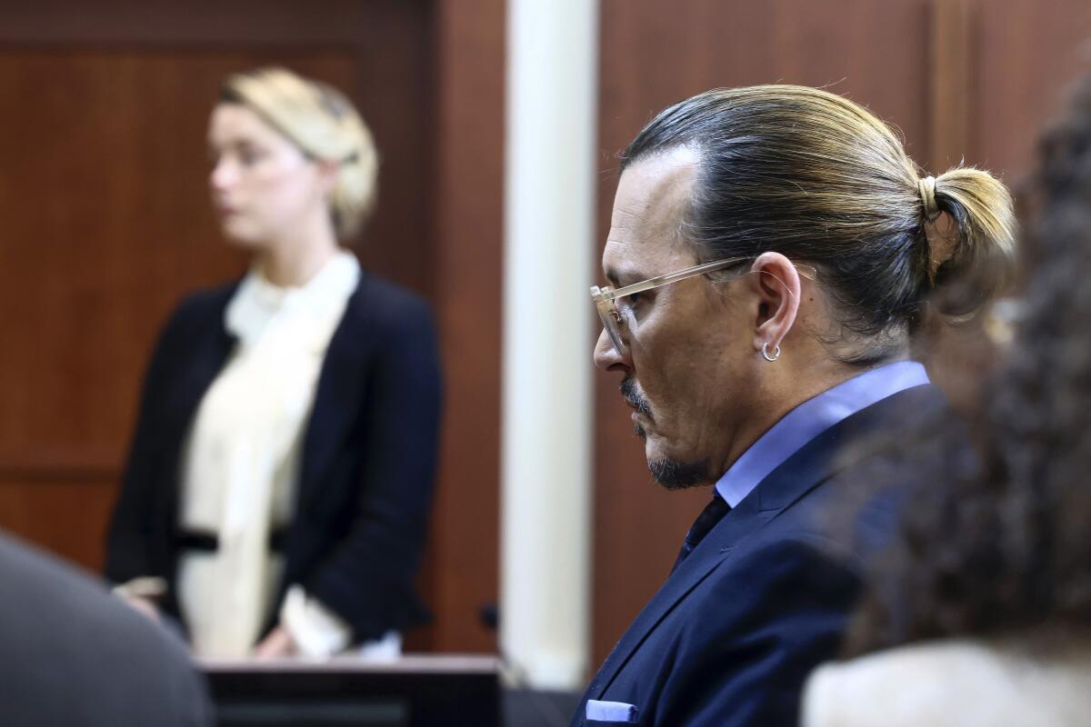 La actriz Amber Heard, izquierda al fondo, y el actor Johnny Depp comparecen en la corte 