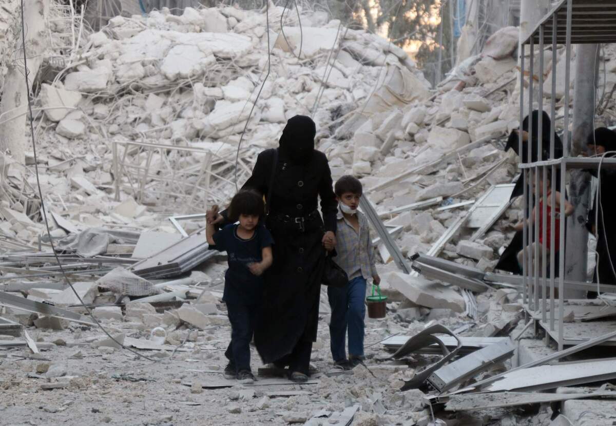 A Syrian family leaves the area following an airstrike in Aleppo.