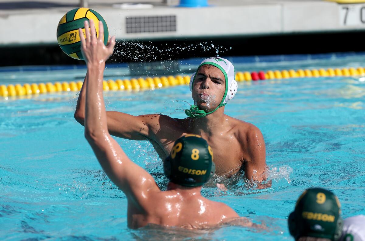 Costa Mesa's Luke De La Jara, top, competes against Edison in a nonleague boys' water polo game on Tuesday.