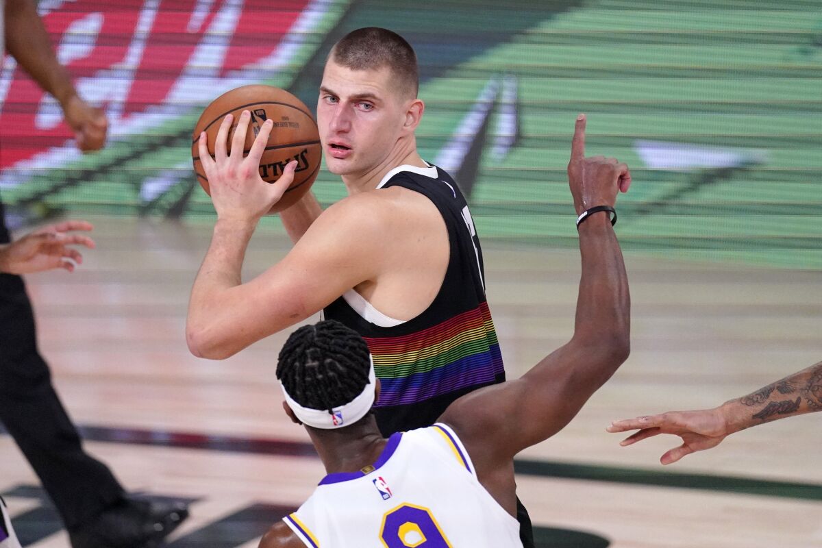 Nuggets center Nikola Jokic looks to make a pass after grabbing a rebound against Lakers guard Rajon Rondo during Game 3.