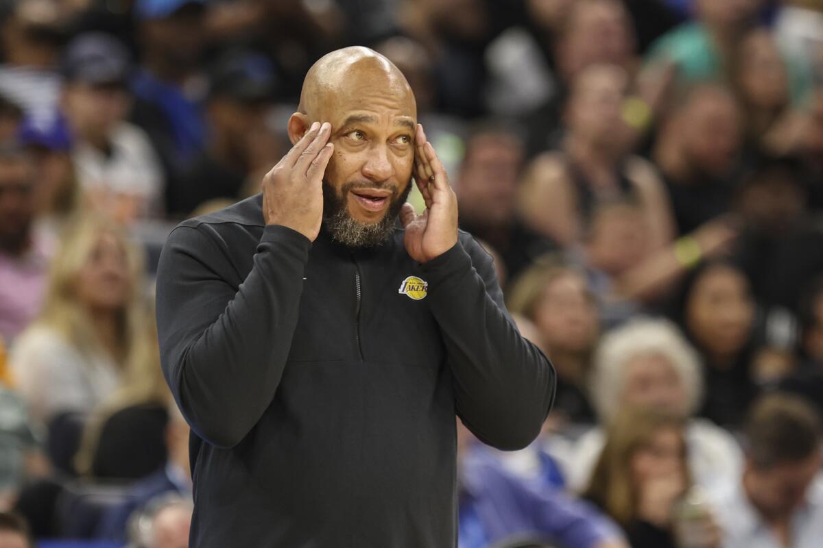 Lakers head coach Darvin Ham rubs his temples as he reacts to a play along the sideline.