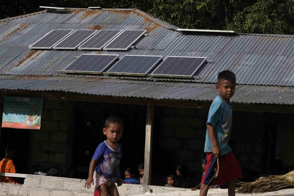ARCHIVO - Niños jugando cerca de unos paneles solares
