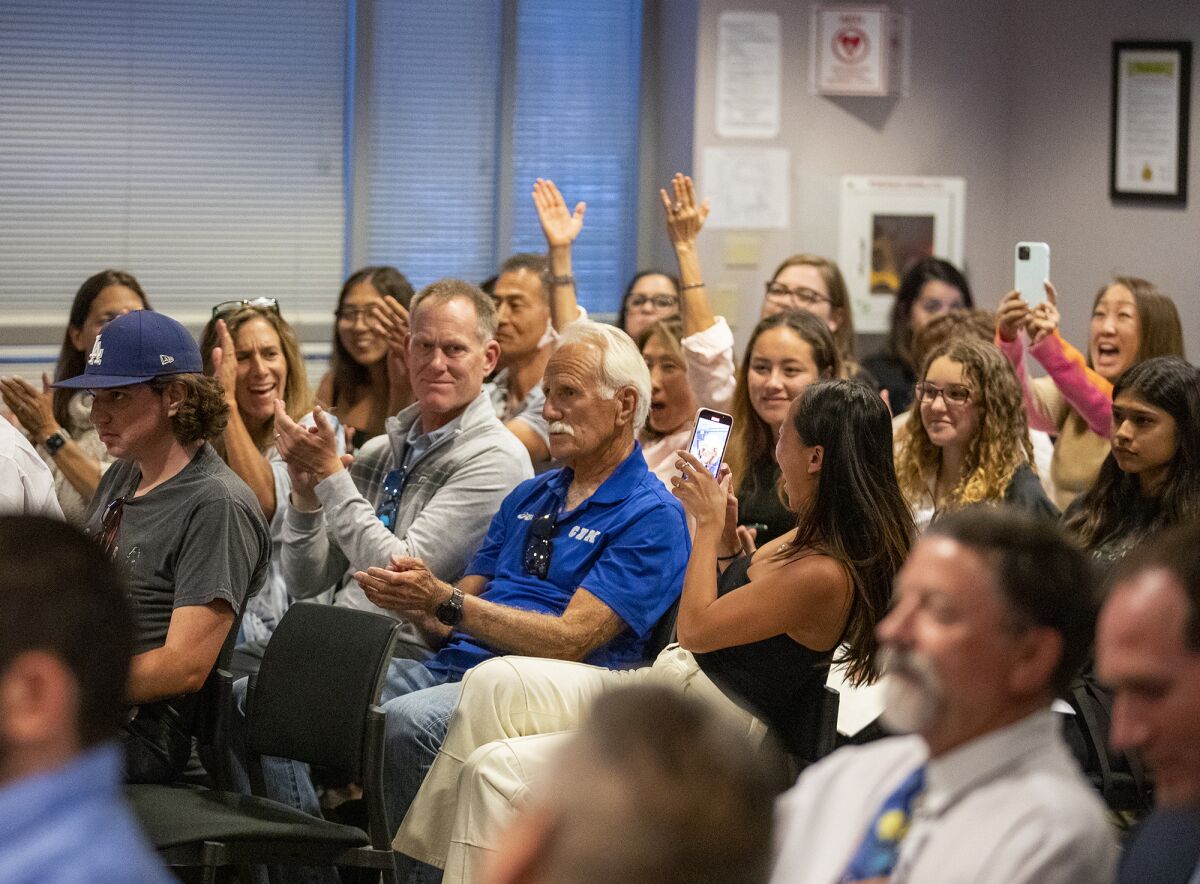 Supporters cheer for Bill Sumner after the school board voted unanimously to name the new track after him on Tuesday.