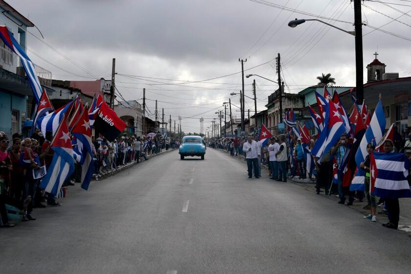 People wait Thursday to see the convoy carrying the ashes of Cuban leader Fidel Castro at Jatibonico, Cuba.
