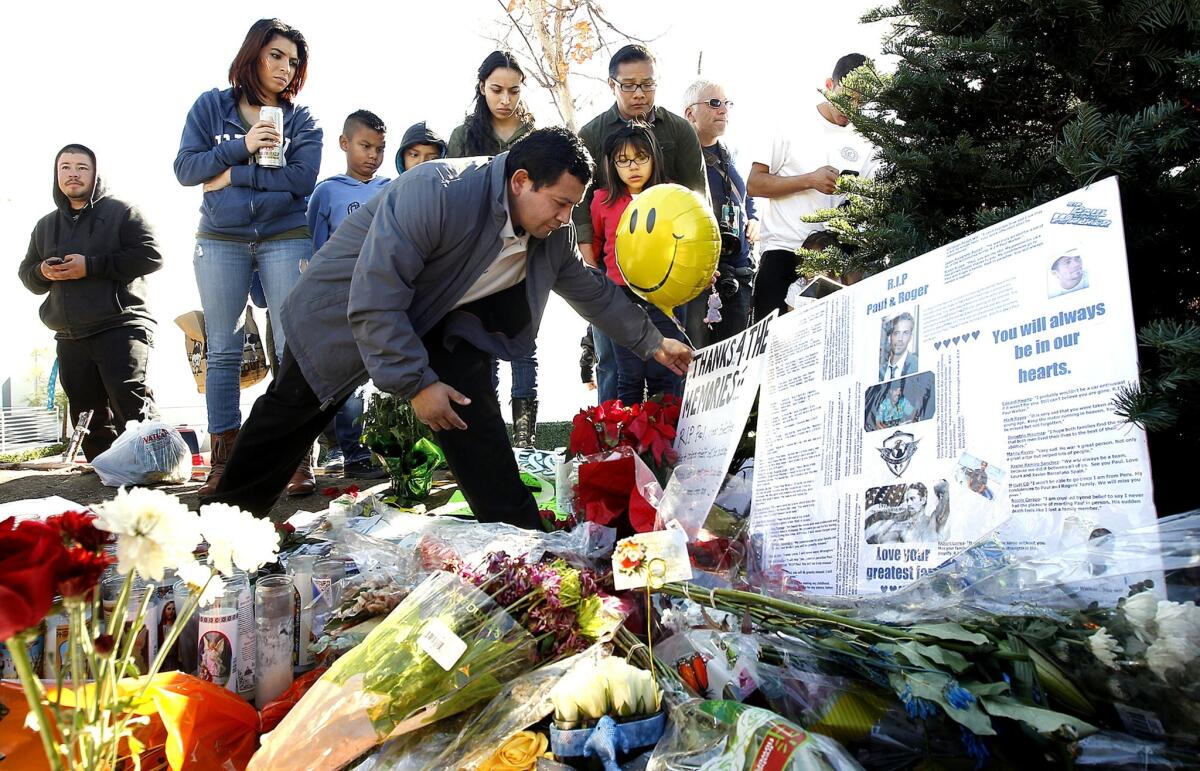 Rafael Lopez of Santa Clarita places a sign at a memorial at the site where actor Paul Walker and his friend Roger Rodas were killed in a car crash Nov. 30, 2013.