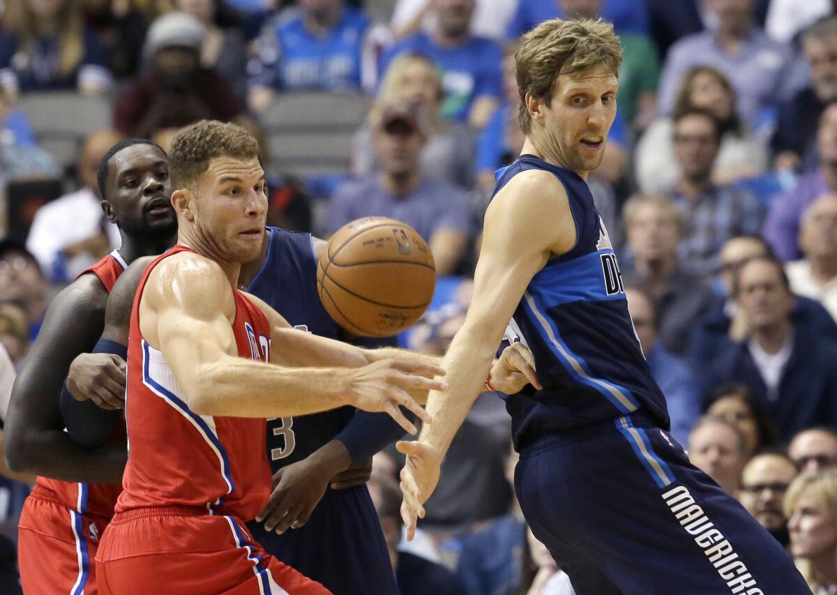 Clippers forward Blake Griffin and Mavericks forward Dirk Nowitzki reach for a loose ball during a Nov. 11 game in Dallas.