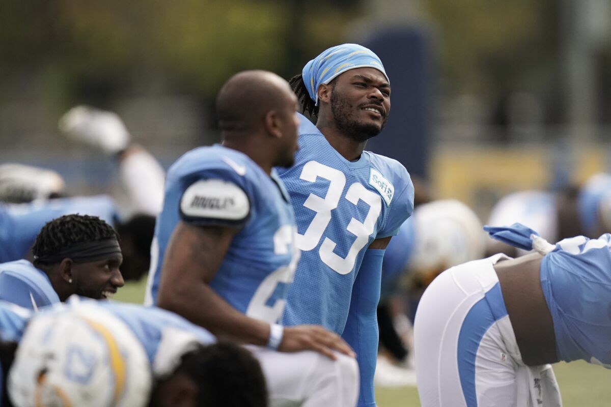 Chargers safety Derwin James (33) and cornerback Chris Harris Jr. chat while stretching 