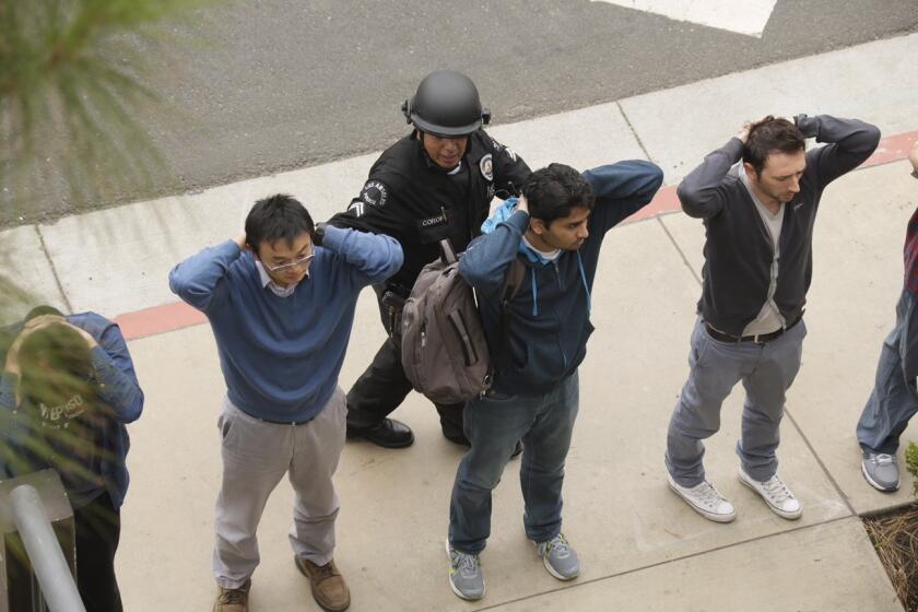 A police officer checks people on the UCLA campus during lockdown.