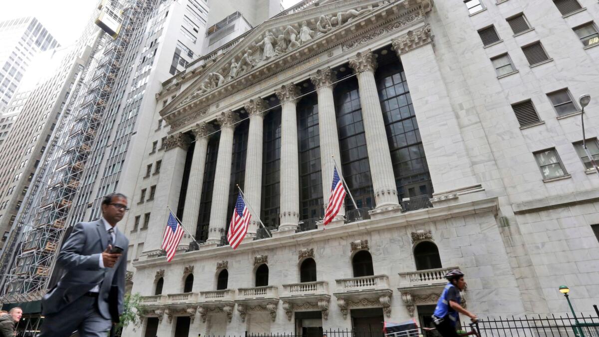 People pass the New York Stock Exchange.