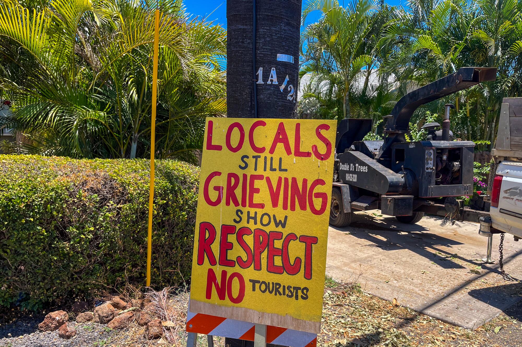 Sign on a telephone pole reads "Locals still grieving Show respect No tourists"