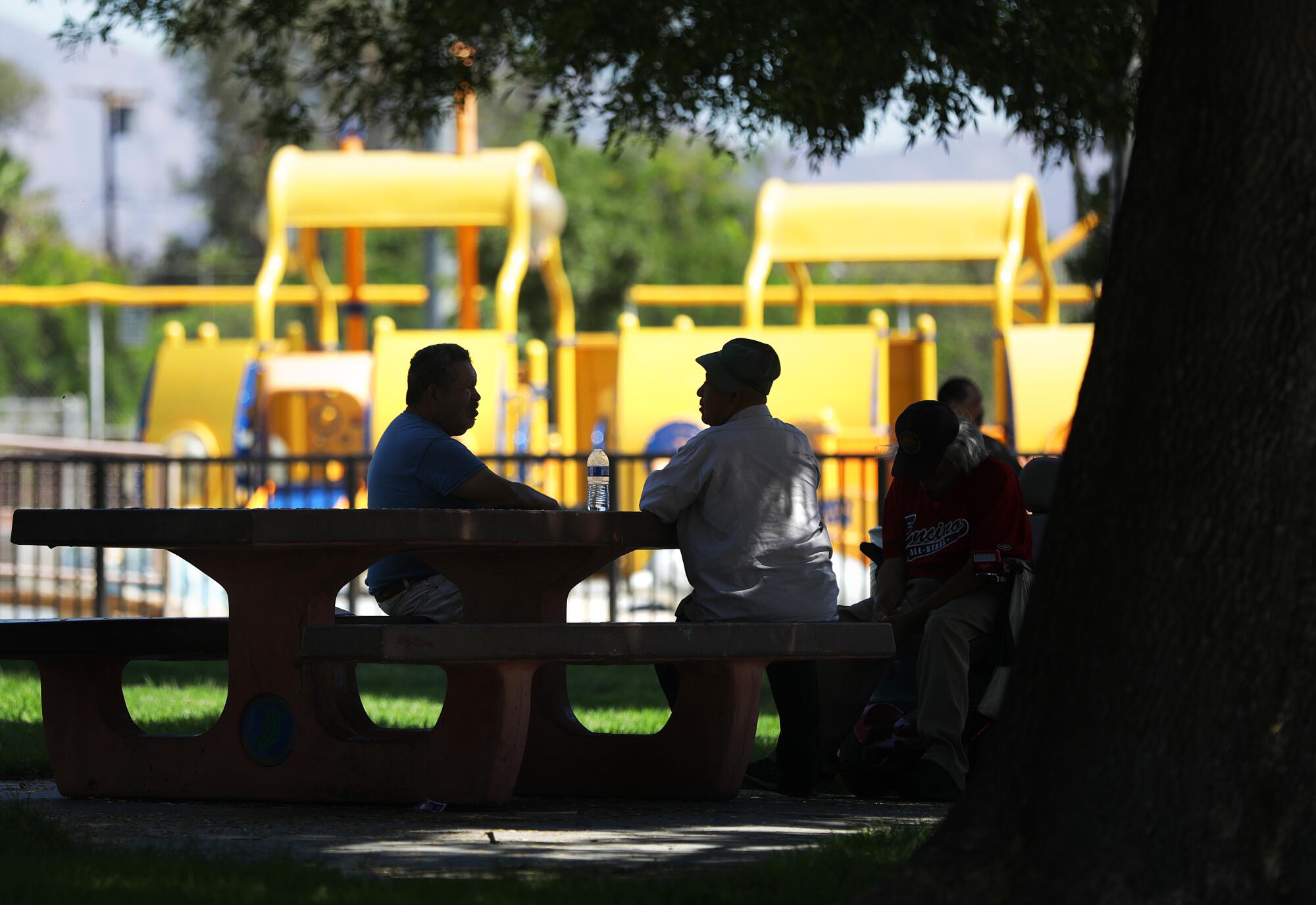 People stay cool in the shade at the Hubert H. Humphrey Recreation Center in Pacoima on Aug. 2.