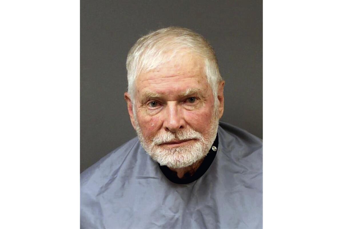 A man with gray hair and a beard looks into the camera in a sheriff's office photo.