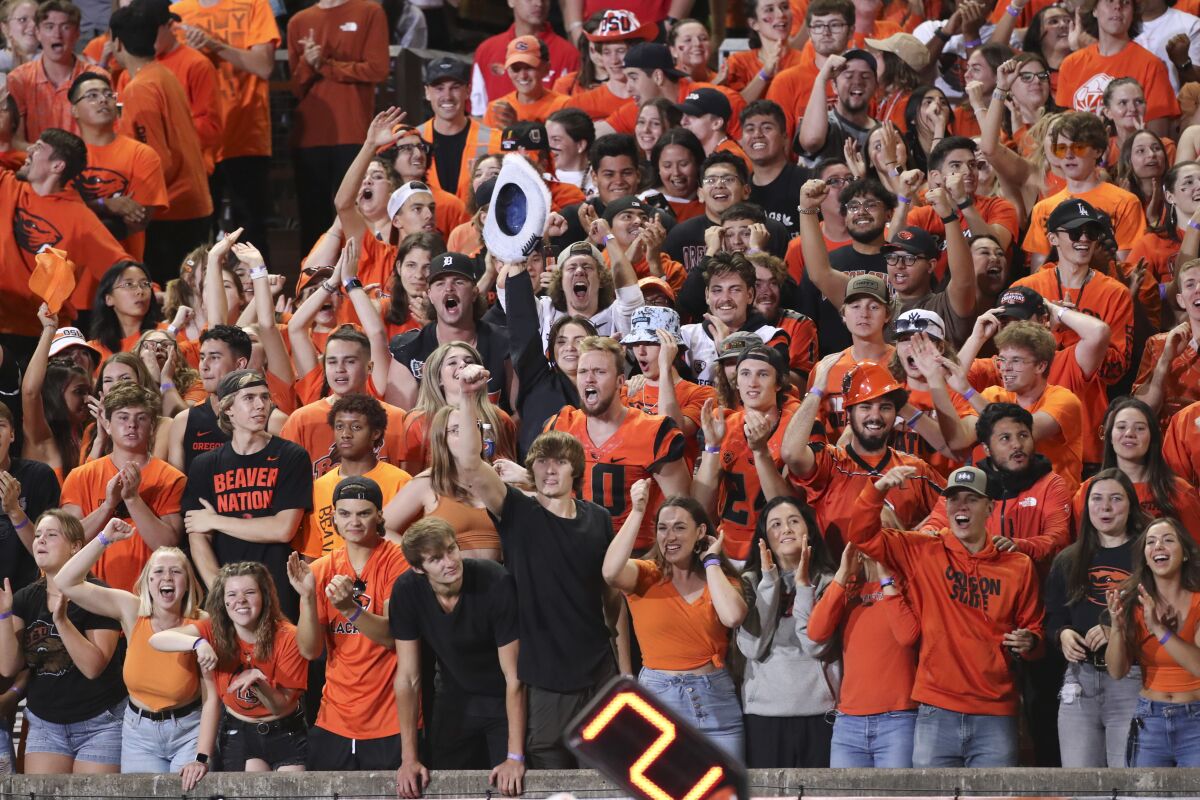 Oregon State fans cheer and raise their arms.