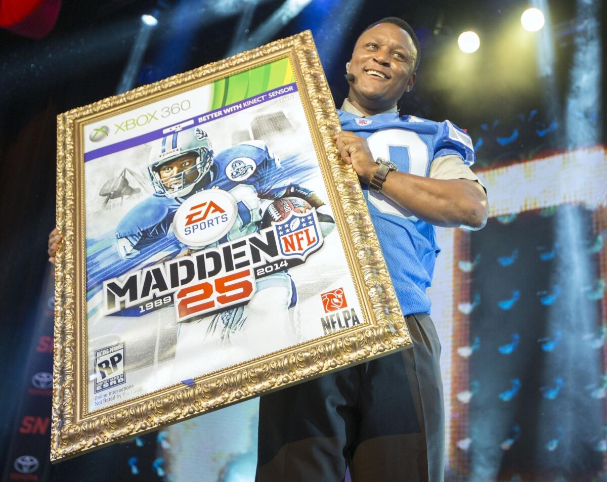 Hall of Fame running back Barry Sanders holds up a mock-up of the Madden 25 video game cover during the EA Sports Madden NFL 25 cover reveal Wednesday on SportsNation in New York City.