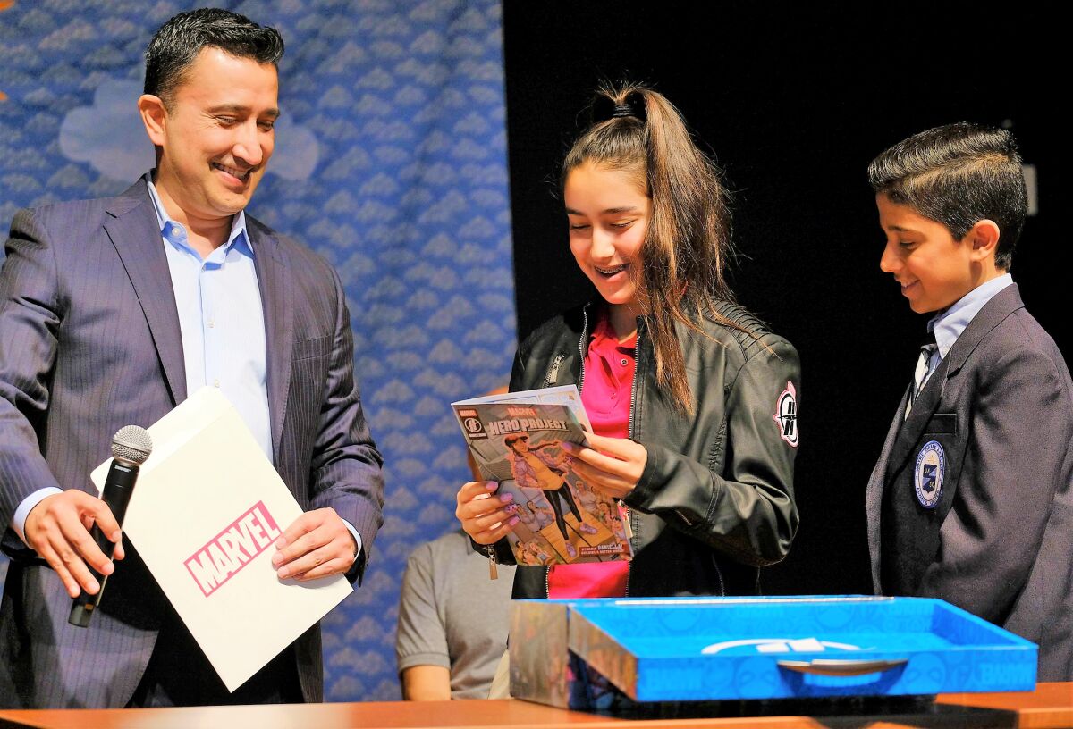 Daniella Benetiz, 15, takes a look at a new special edition comic book published by Marvel, which features her as its superhero. To her right is her brother, Gabriel, 12. Daniella was selected as one of 20 kids nationwide to have a role in Marvel's Hero Project. Her episode will begin streaming on Disney+ on Feb. 7.