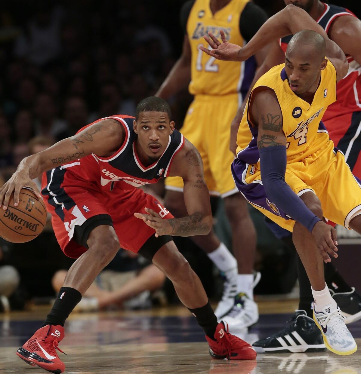 Wizards forward Trevor Ariza dribbles around Lakers defender Kobe Bryant during the first half.